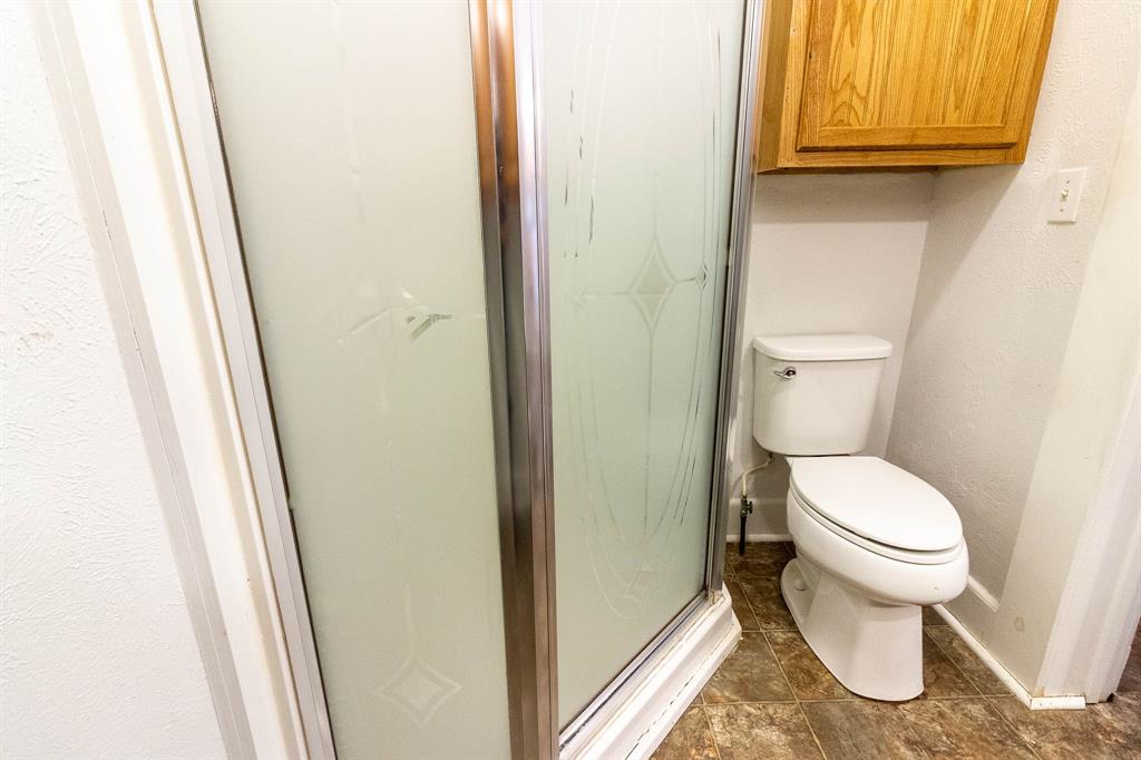 801 South Sutton Street Mabank, TX 75147 - Photo 14 of 26 a white toilet sitting next to a shower