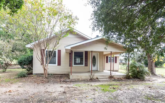 a front view of a house with a tree