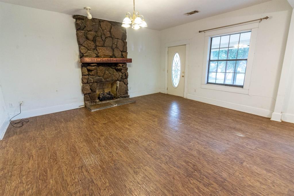 801 South Sutton Street Mabank, TX 75147 - Photo 8 of 26 an empty room with chandelier fan and windows