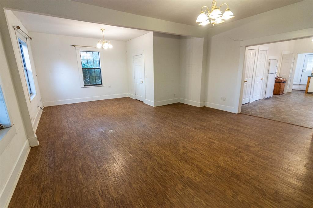 801 South Sutton Street Mabank, TX 75147 - Photo 9 of 26 an empty room with wooden floor and windows