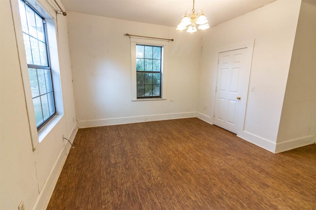 801 South Sutton Street Mabank, TX 75147 - Photo 10 of 26 wooden floor in an empty room with a window