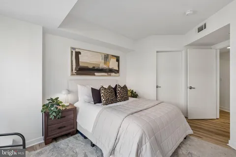 a bedroom with a bed and a painting on the wall