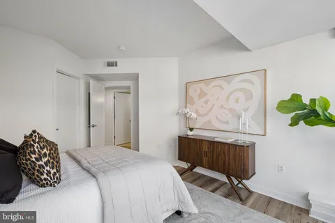 a bedroom with a bed and a painting on the wall
