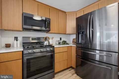 a kitchen with stainless steel appliances a refrigerator stove and microwave