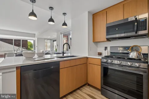 a kitchen with stainless steel appliances a stove a sink and a microwave