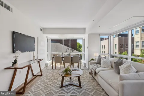 a living room with furniture a flat screen tv and a large window