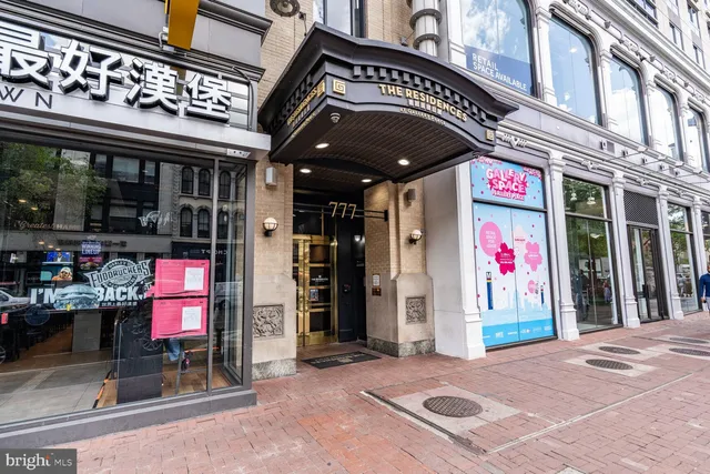 a front view of multi story commercial building with retail shops