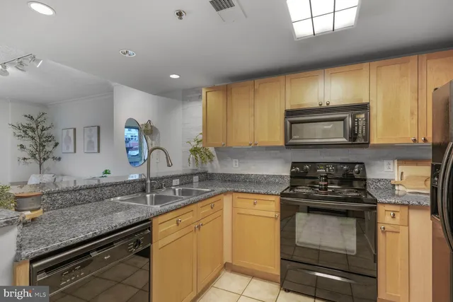 a kitchen with granite countertop a sink stainless steel appliances and cabinets