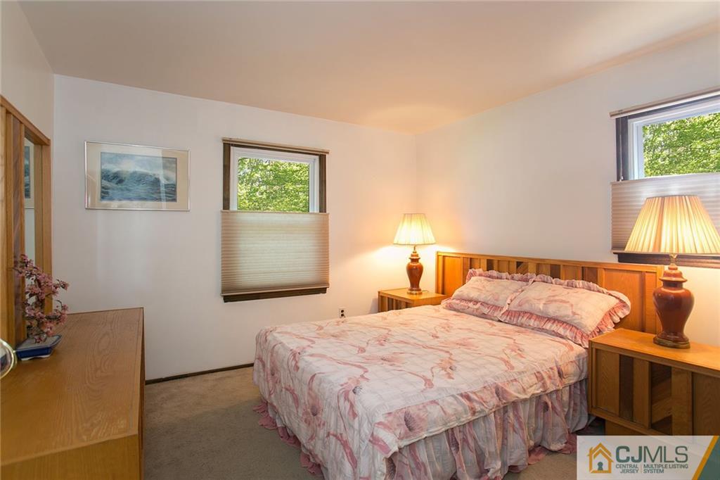 7 Roxy Avenue Edison, NJ 08820 - Photo 14 of 24 a bedroom with a bed and a lamp on dresser