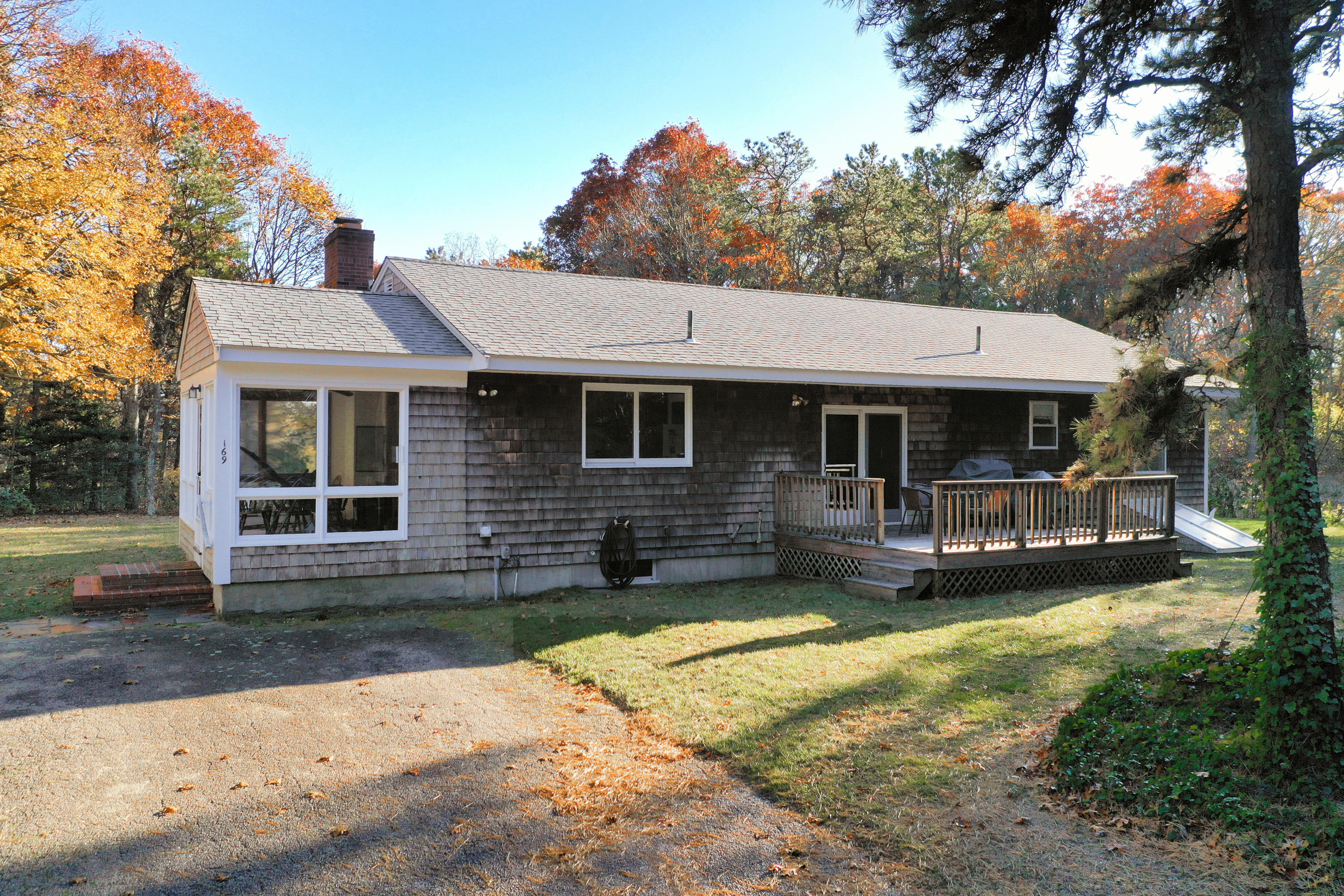169-173 Old Post Road Centerville, MA 02632 - Photo 13 of 50 a front view of a house with a yard table and chairs