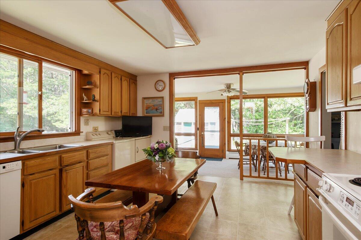 169-173 Old Post Road Centerville, MA 02632 - Photo 23 of 50 a kitchen with a table chairs stove and cabinets