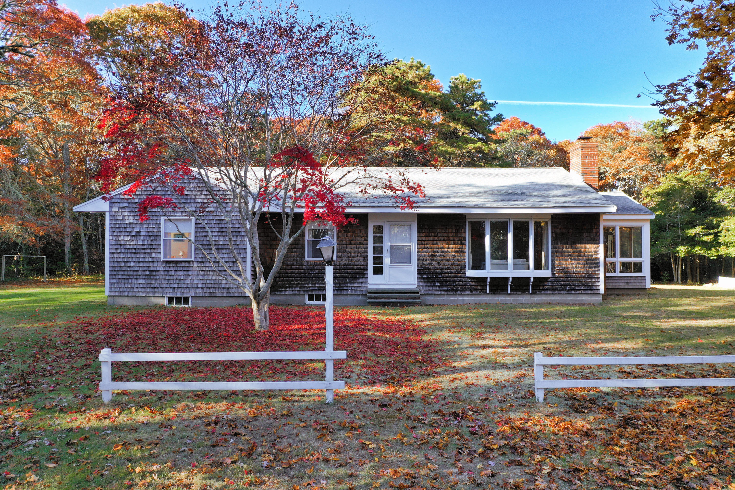 169-173 Old Post Road Centerville, MA 02632 - Photo 6 of 50 a front view of a house with a yard table and chairs