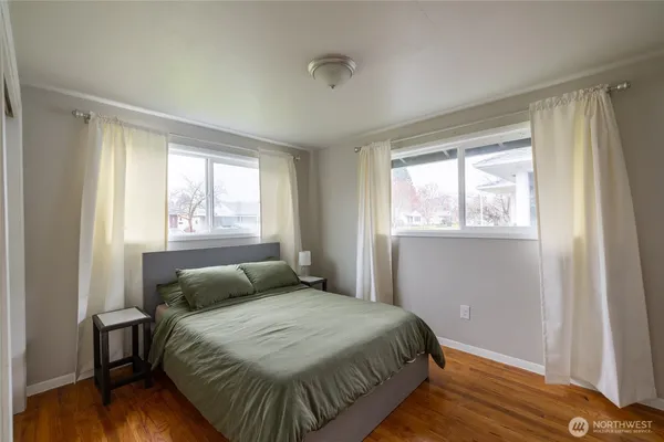 a bedroom with a bed and wooden floor
