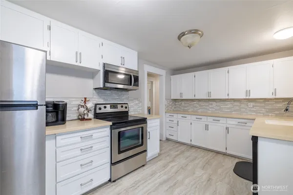 a kitchen with granite countertop a sink stainless steel appliances and cabinets