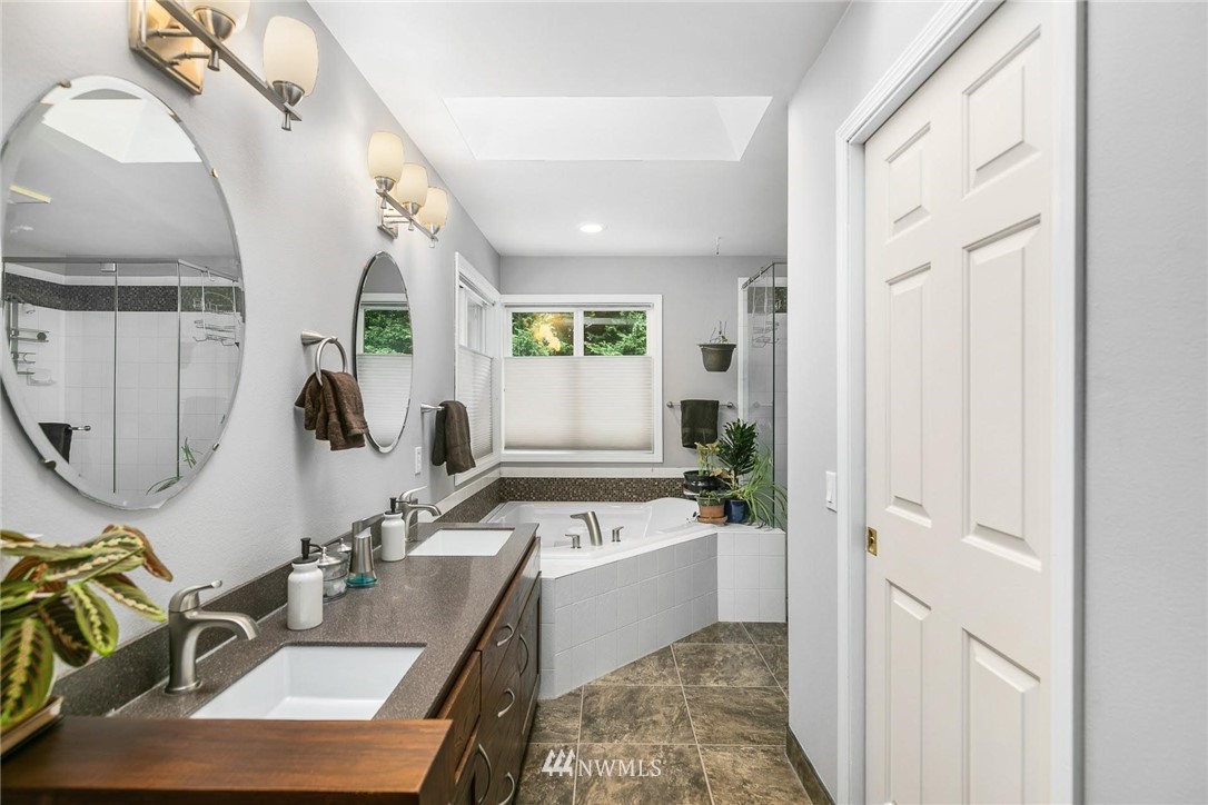 23809 Southeast 243rd Street Maple Valley, WA 98038 - Photo 20 of 40 a bathroom with a sink a mirror and a bathtub