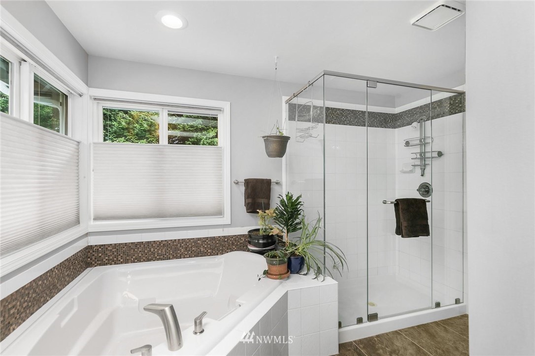 23809 Southeast 243rd Street Maple Valley, WA 98038 - Photo 22 of 40 a bathroom with a tub a potted plant and a shower