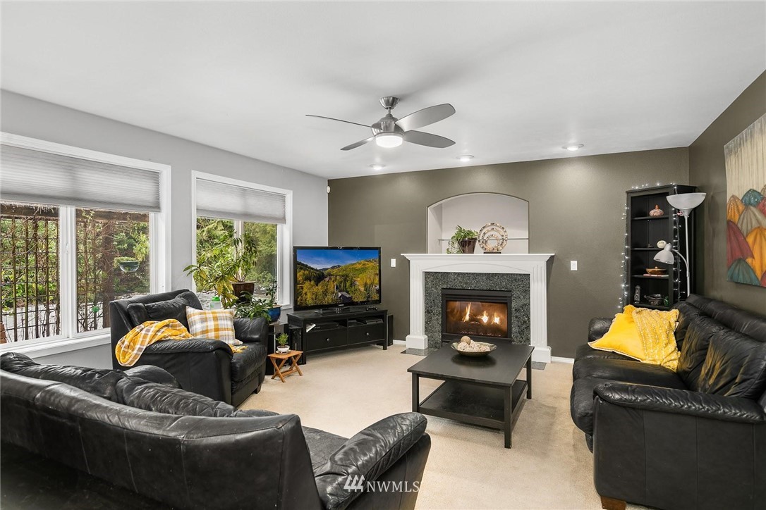 23809 Southeast 243rd Street Maple Valley, WA 98038 - Photo 7 of 40 a living room with furniture a fireplace and a flat screen tv