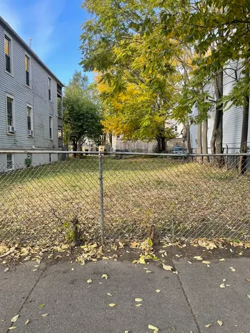 a view of a yard with wooden fence