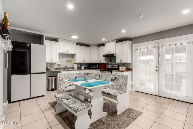 a kitchen with stainless steel appliances granite countertop a refrigerator a sink a stove top oven a counter space and cabinets