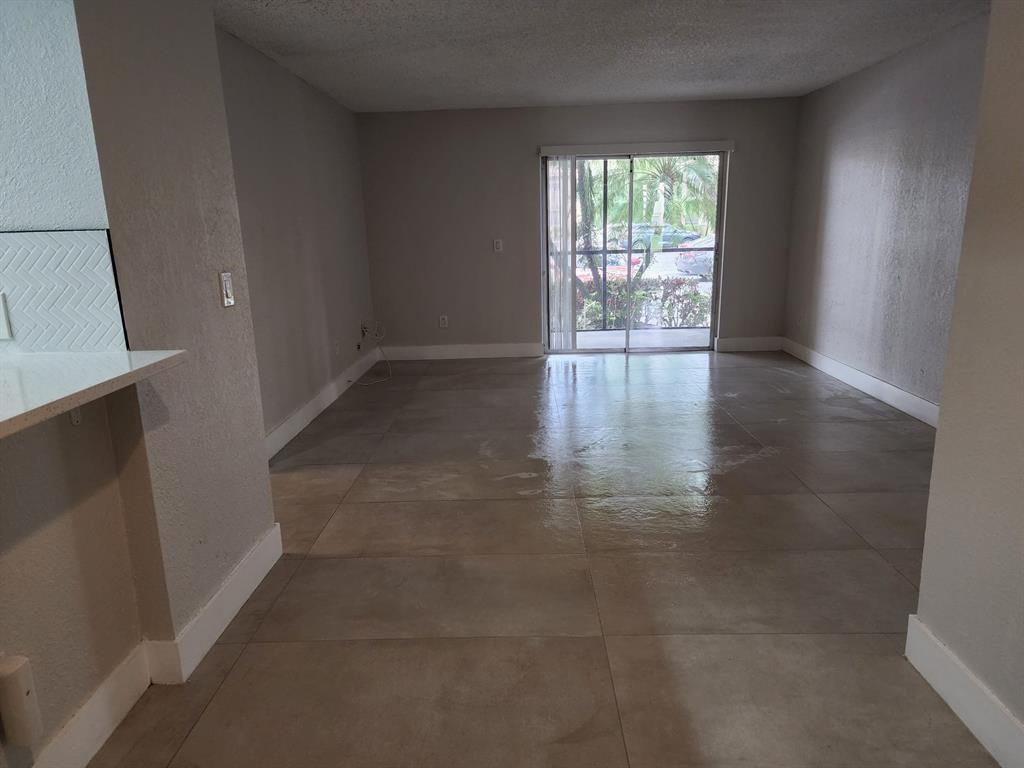 1229 Southwest 46th Avenue, Unit 405 Pompano Beach, FL 33069 - Photo 14 of 26 an empty room with wooden floor and windows