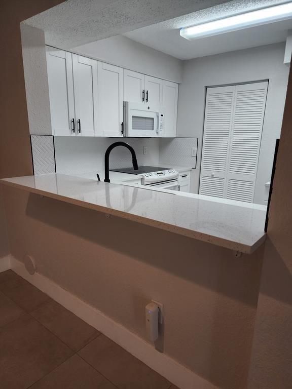 1229 Southwest 46th Avenue, Unit 405 Pompano Beach, FL 33069 - Photo 19 of 26 a kitchen with stainless steel appliances a sink dishwasher a stove and white cabinets