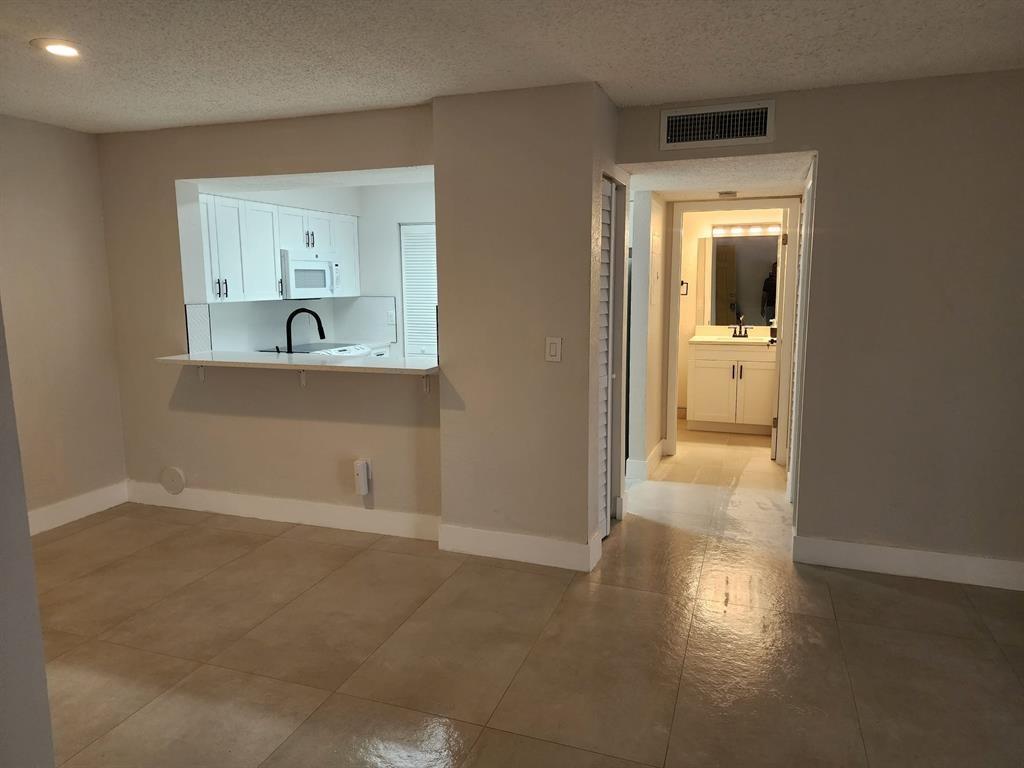 1229 Southwest 46th Avenue, Unit 405 Pompano Beach, FL 33069 - Photo 25 of 26 a view of wooden floor and a cabinet in a room