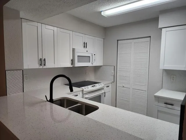 a kitchen with a sink a stove and cabinets