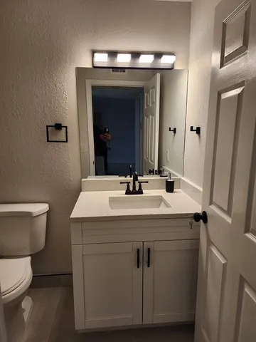a bathroom with a toilet sink and mirror