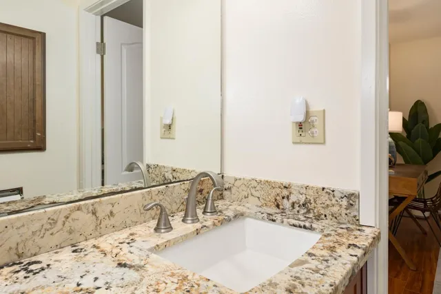 a bathroom with a granite countertop sink and a mirror