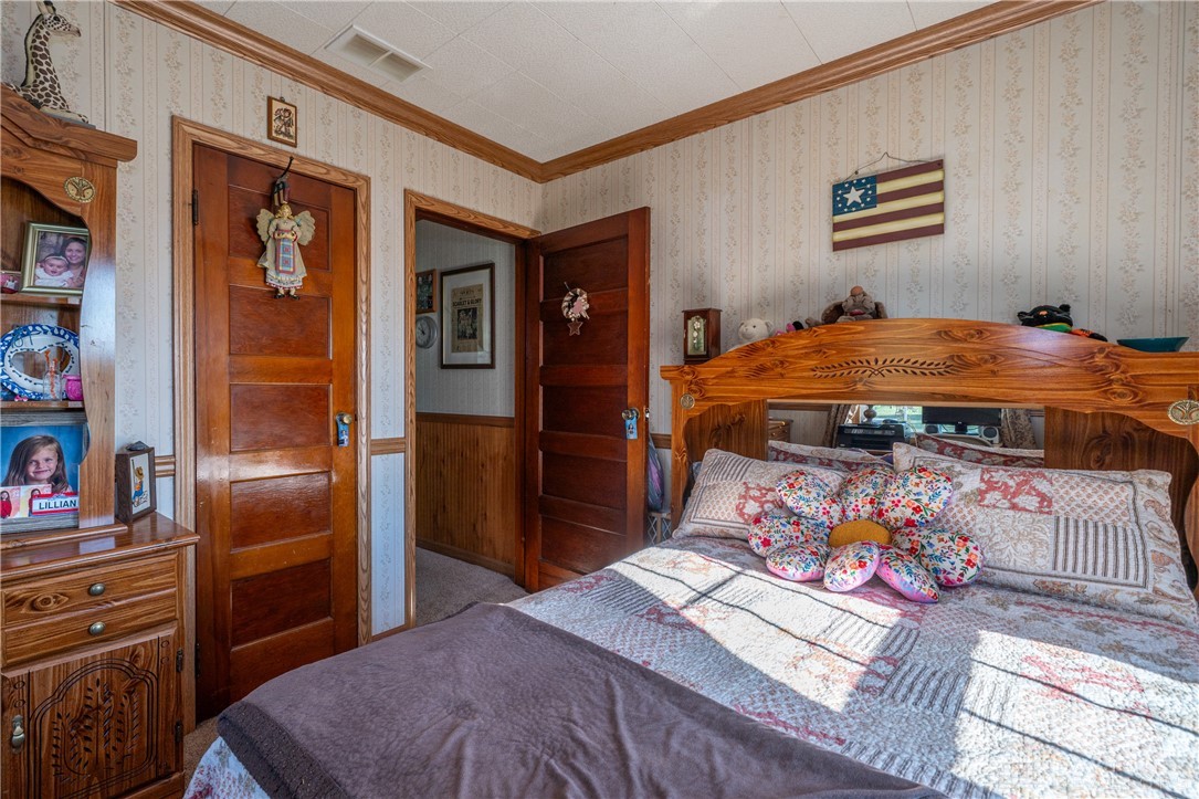1599 Garringer Road Jamestown, OH 45335 - Photo 23 of 73 This cozy bedroom features warm wood trim, creating a welcoming and intimate personal retreat.