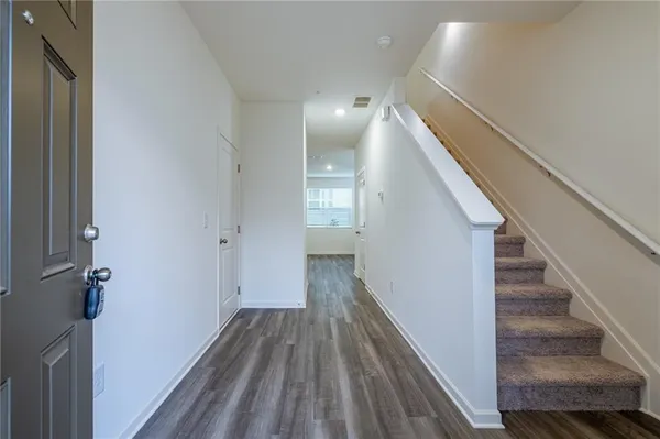 a view of a hallway with wooden floor and staircase