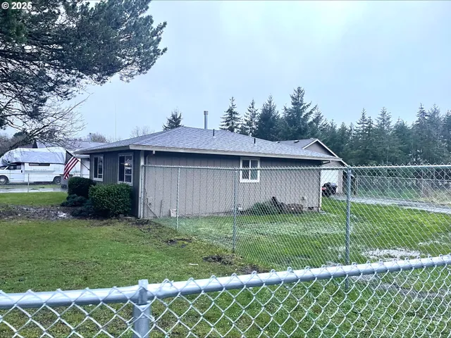 a view of a yard in front of a house with a large tree