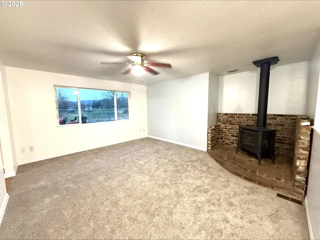 a view of a hallway with wooden floor and a kitchen