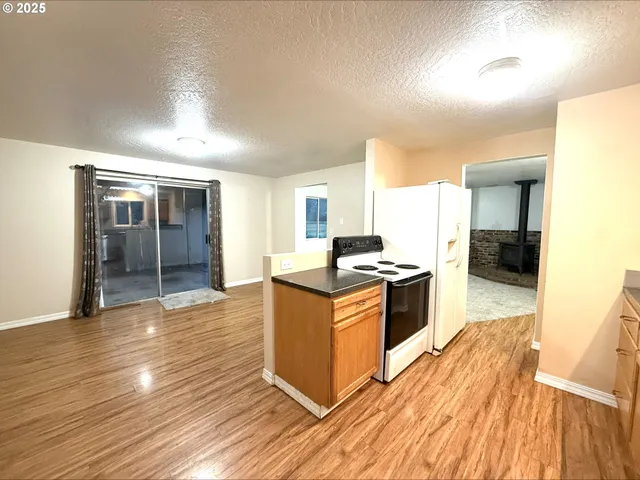 a kitchen with stainless steel appliances granite countertop a sink and wooden floors