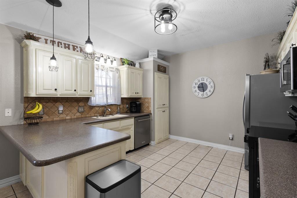 1701 Oakmeadow Drive Decatur, TX 76234 - Photo 9 of 39 a kitchen with a refrigerator and a stove top oven