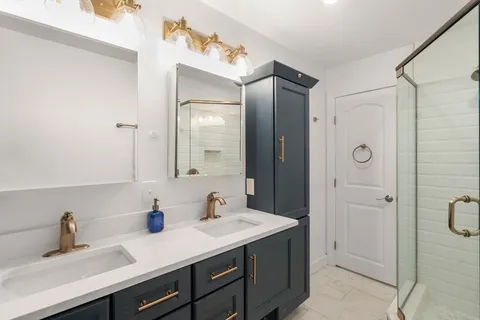 a bathroom with a shower sink and mirror