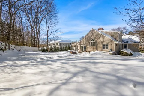a view of house with a yard covered in snow