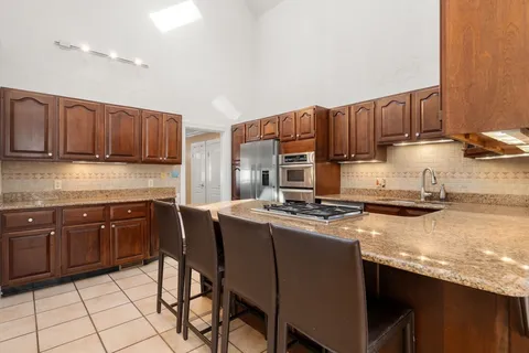 a kitchen with stainless steel appliances granite countertop a sink stove and refrigerator