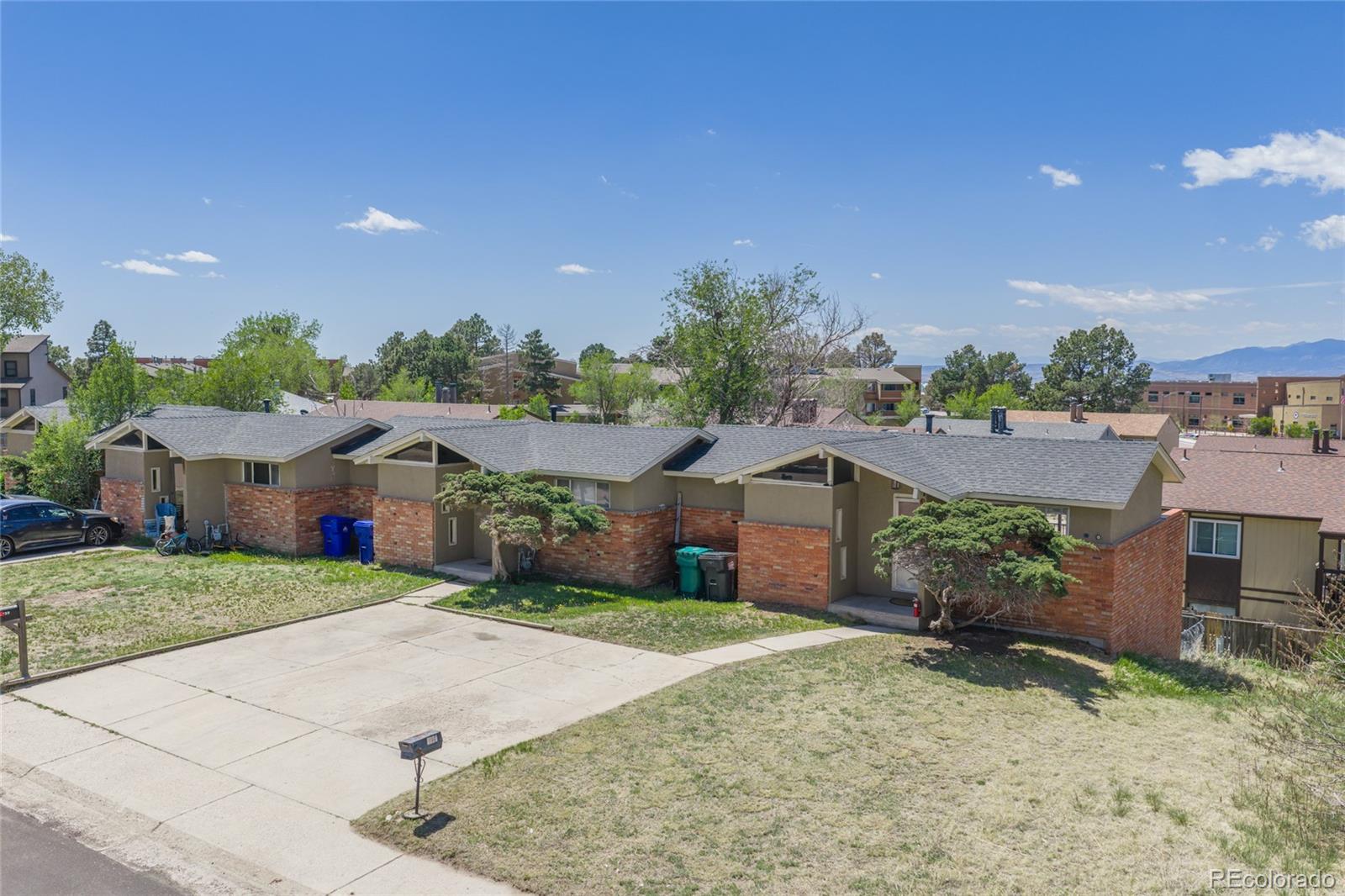 a view of a house with a yard and large tree