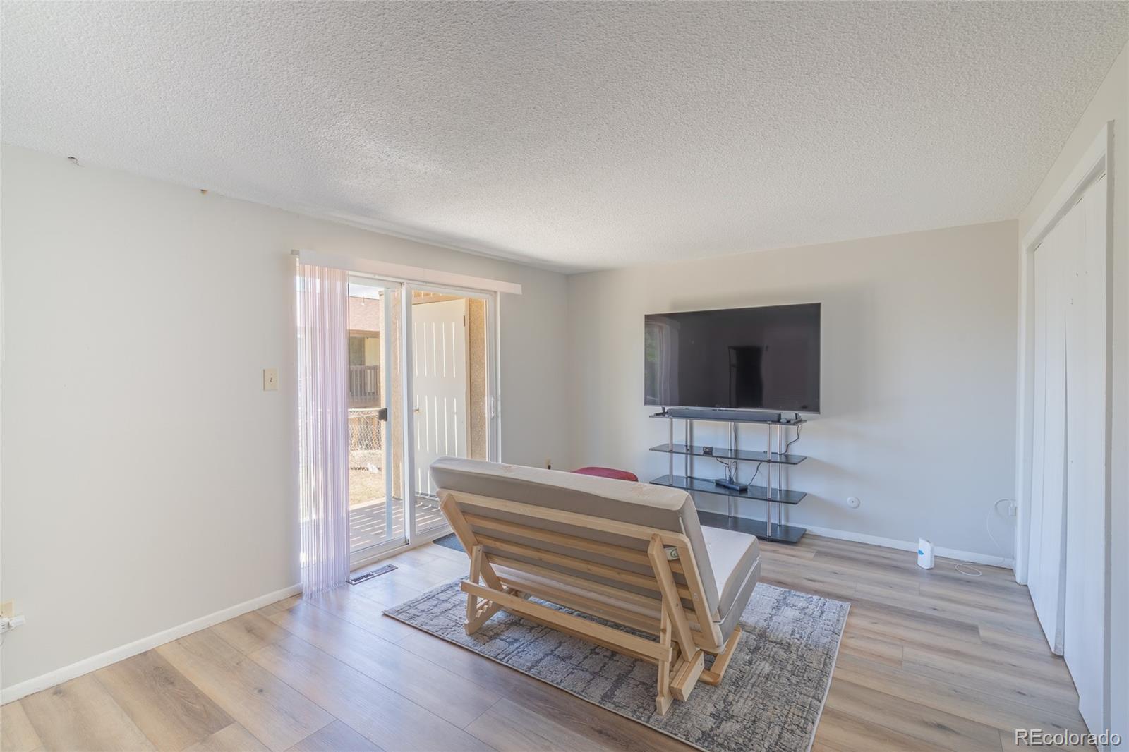 6727 Dale Road Colorado Springs, CO 80915 - Photo 6 of 18 a room with a chair and a flat screen tv