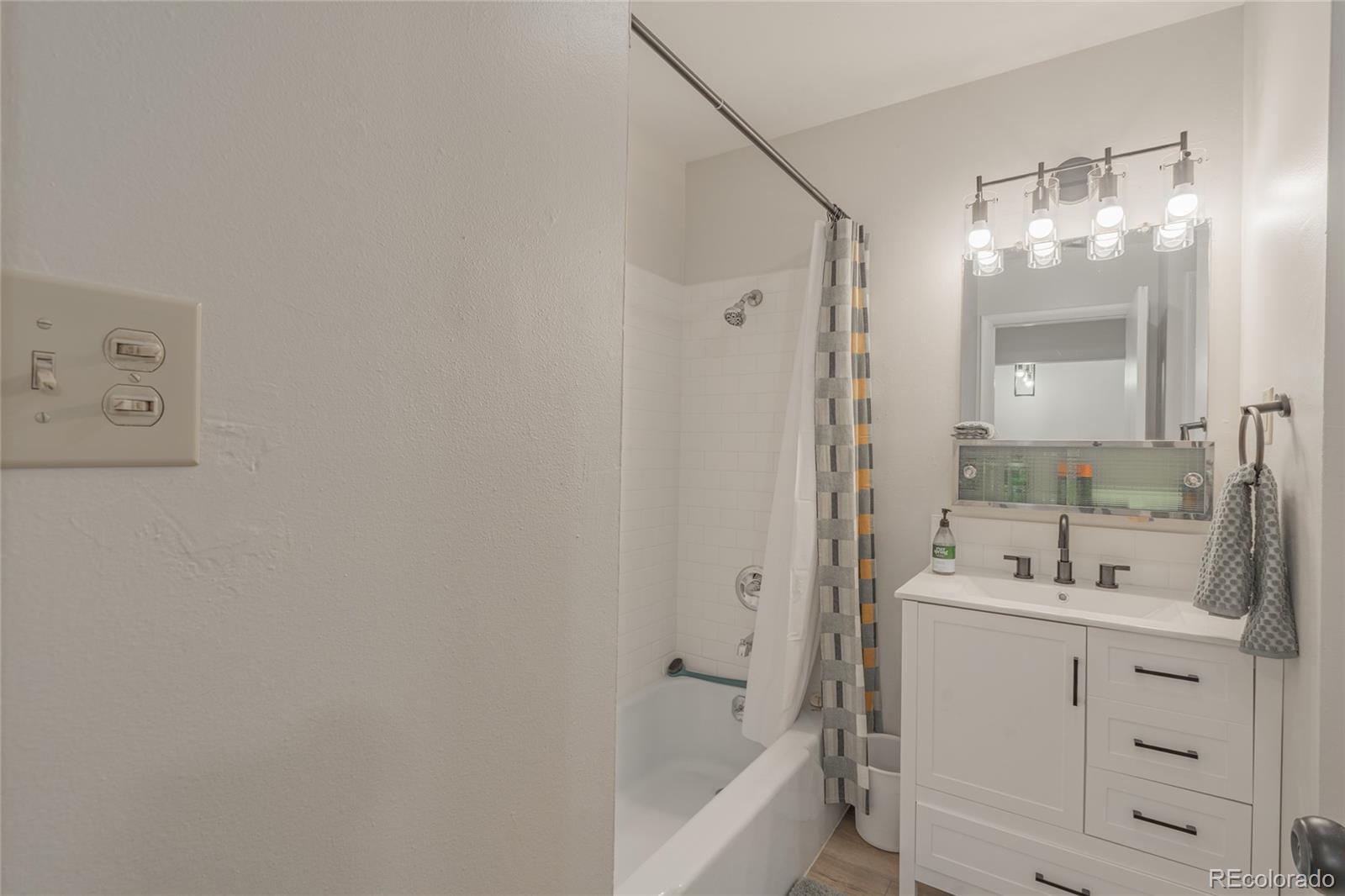 6727 Dale Road Colorado Springs, CO 80915 - Photo 10 of 18 a bathroom with a tub sink vanity and mirror