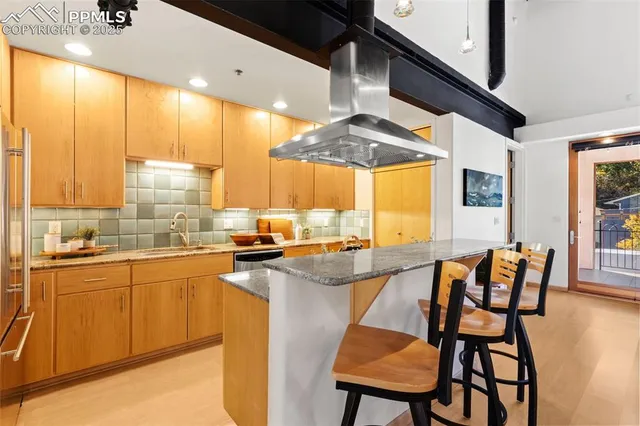 a kitchen with stainless steel appliances kitchen island granite countertop a stove a sink and a refrigerator