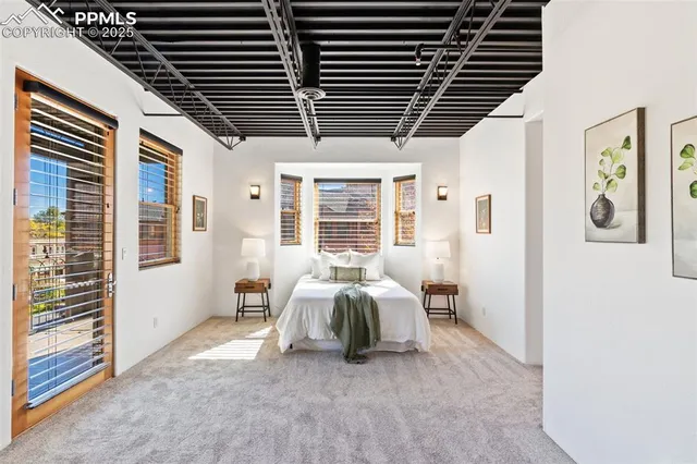 a spacious bedroom with a bed and a chandelier