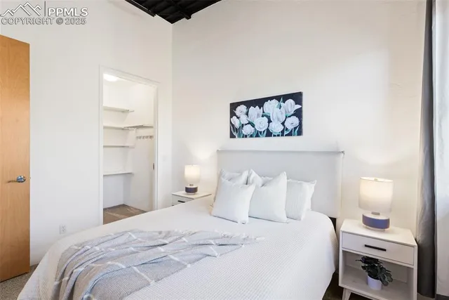 a bedroom with a bed and a painting on the wall