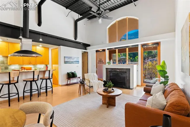 a living room with furniture a fireplace and a floor to ceiling window