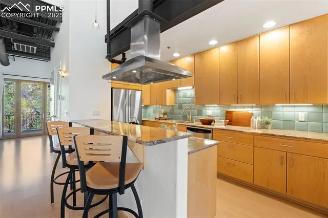 a kitchen with stainless steel appliances kitchen island granite countertop a table and chairs in it