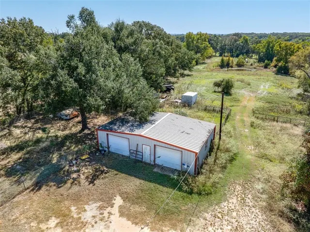 a view of a house with a yard and large tree