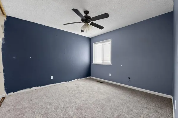 en empty room with window and ceiling fan