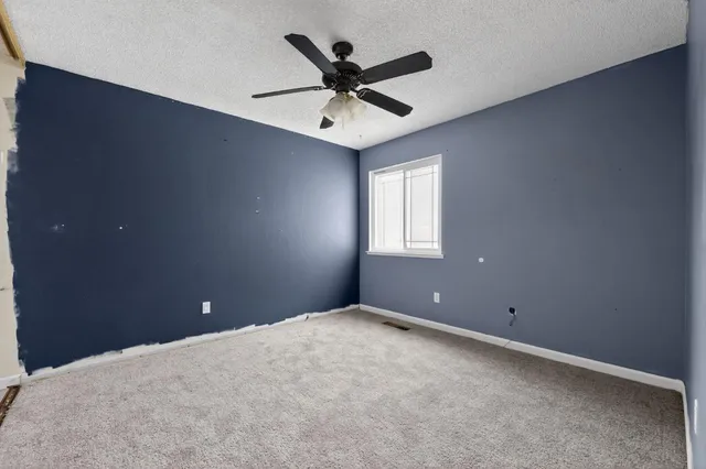 en empty room with window and ceiling fan
