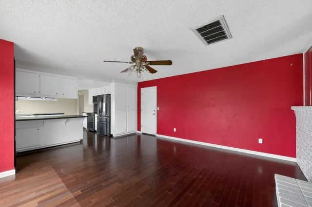 a view of empty room with wooden floor and window